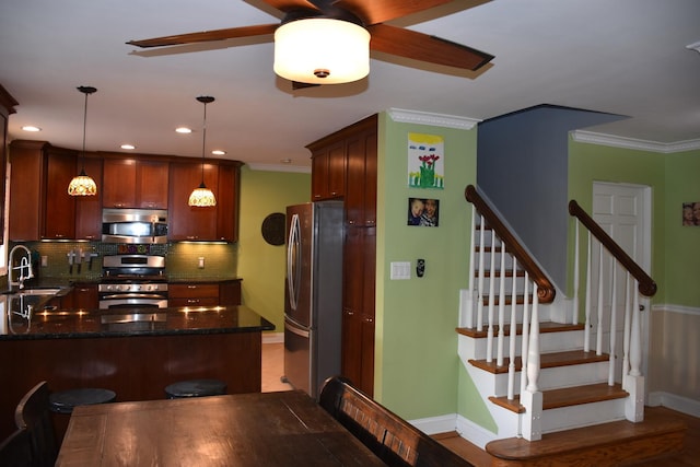 kitchen featuring tasteful backsplash, crown molding, decorative light fixtures, appliances with stainless steel finishes, and kitchen peninsula