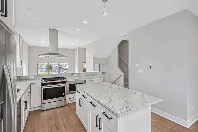 kitchen with ventilation hood, white cabinetry, a center island, stainless steel appliances, and light hardwood / wood-style flooring