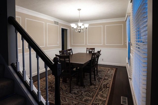 dining area featuring a notable chandelier, dark wood-type flooring, and ornamental molding