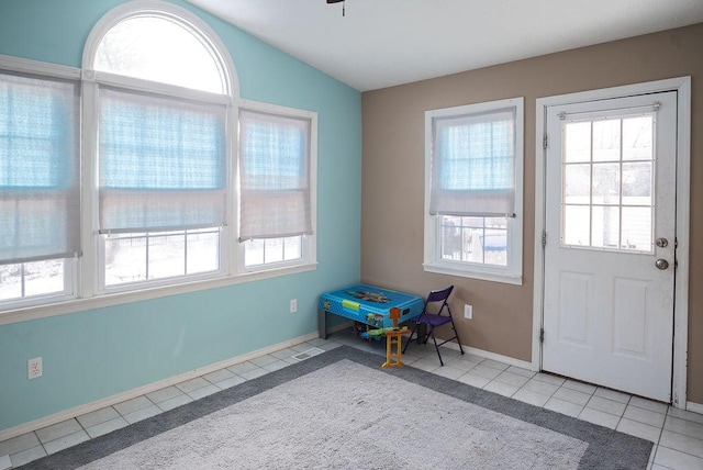 doorway to outside featuring vaulted ceiling and light tile patterned floors