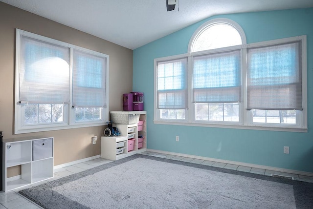 rec room with lofted ceiling and light tile patterned floors