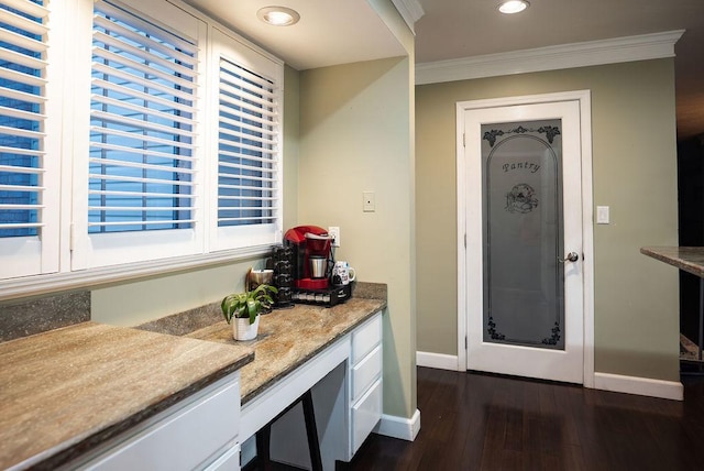 kitchen featuring ornamental molding, dark hardwood / wood-style floors, and light stone countertops