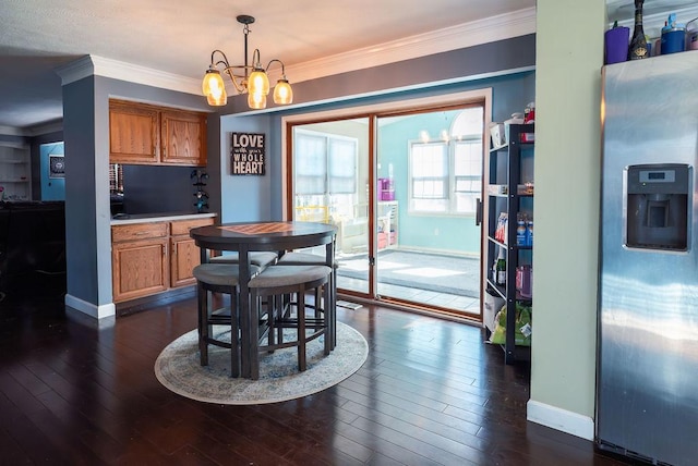 dining space with ornamental molding, a notable chandelier, and dark hardwood / wood-style flooring