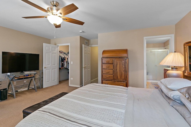 bedroom with ensuite bath, a walk in closet, carpet flooring, a closet, and ceiling fan