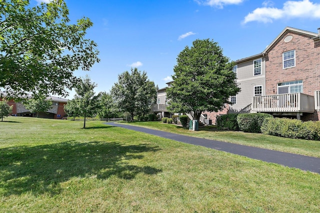 view of community with a wooden deck and a lawn