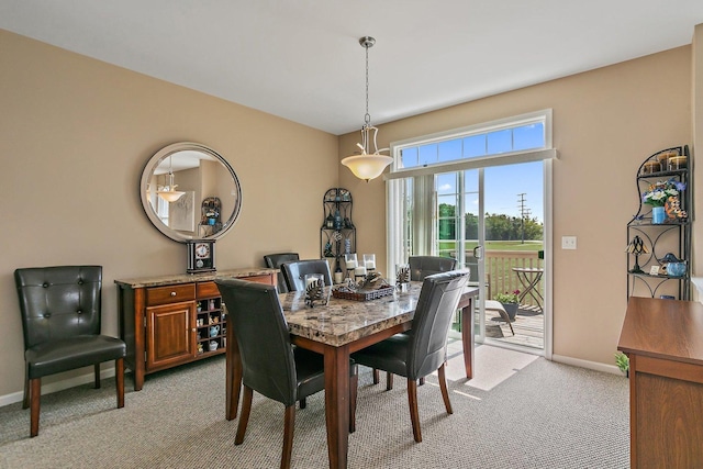 dining space featuring light carpet