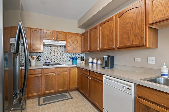 kitchen with backsplash, stainless steel appliances, and sink