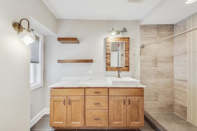 bathroom with tile patterned flooring, vanity, and tiled shower