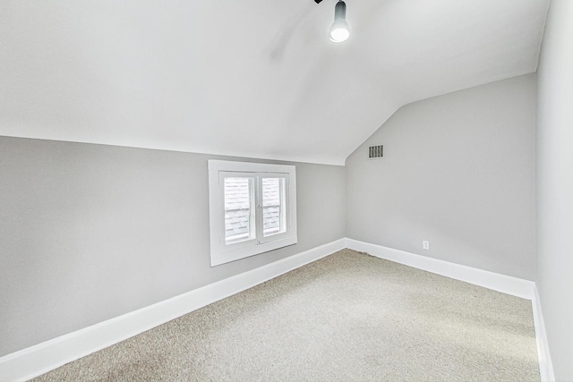 bonus room with vaulted ceiling and carpet