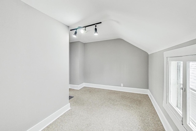 additional living space featuring lofted ceiling and carpet