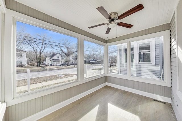 unfurnished sunroom with ceiling fan