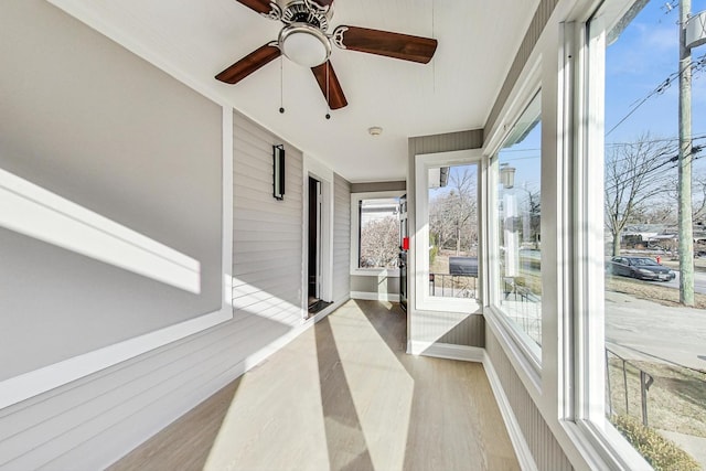 sunroom / solarium featuring plenty of natural light and ceiling fan