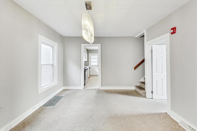 spare room featuring light carpet