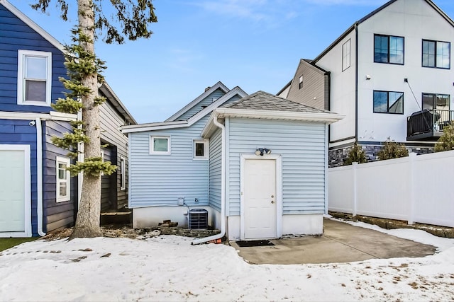 snow covered house featuring central air condition unit