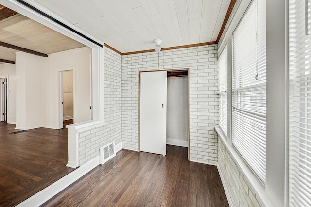 unfurnished room with wood ceiling, brick wall, and dark hardwood / wood-style flooring