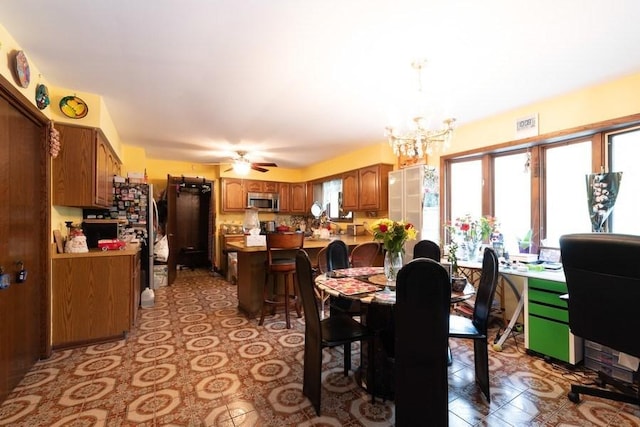 dining area featuring ceiling fan with notable chandelier