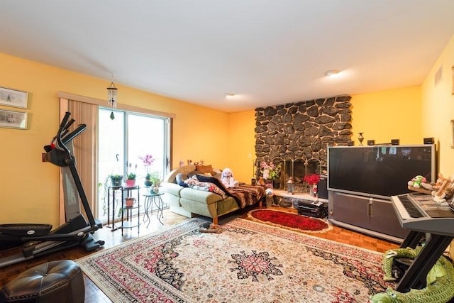 living room featuring hardwood / wood-style flooring and a stone fireplace