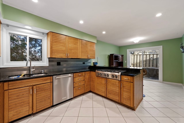 kitchen with sink, light tile patterned floors, kitchen peninsula, stainless steel appliances, and backsplash