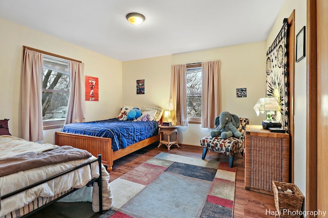 bedroom with dark hardwood / wood-style flooring and multiple windows