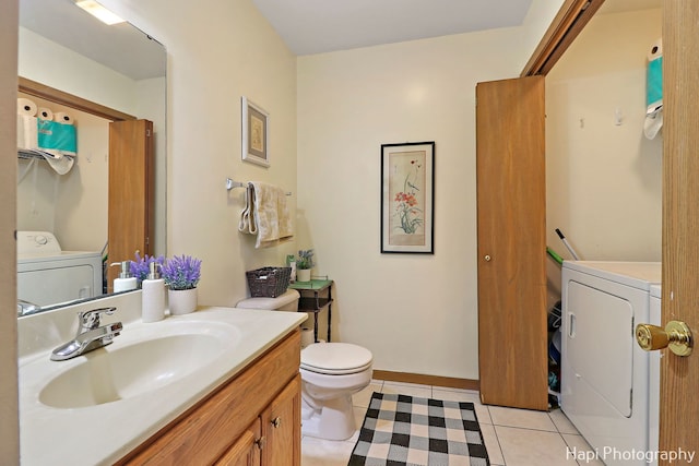 bathroom featuring vanity, washing machine and clothes dryer, tile patterned floors, and toilet