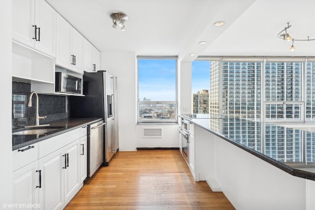 kitchen featuring light wood-type flooring, appliances with stainless steel finishes, sink, and white cabinets