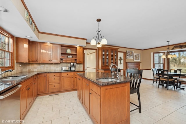 kitchen featuring an inviting chandelier, sink, stainless steel dishwasher, and a center island with sink