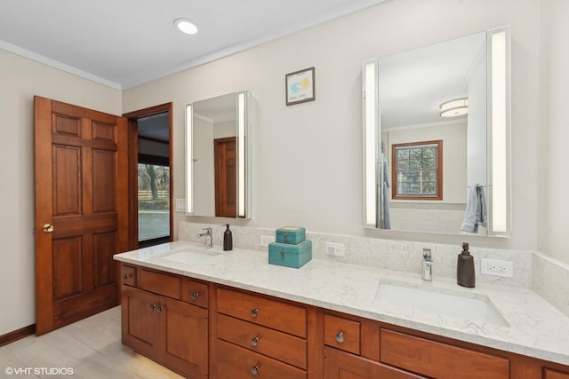 bathroom featuring vanity, ornamental molding, and a healthy amount of sunlight