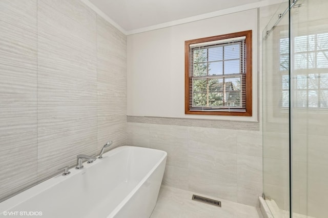 bathroom with ornamental molding, tile walls, and plus walk in shower