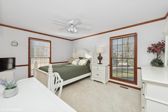 carpeted bedroom with ornamental molding and ceiling fan