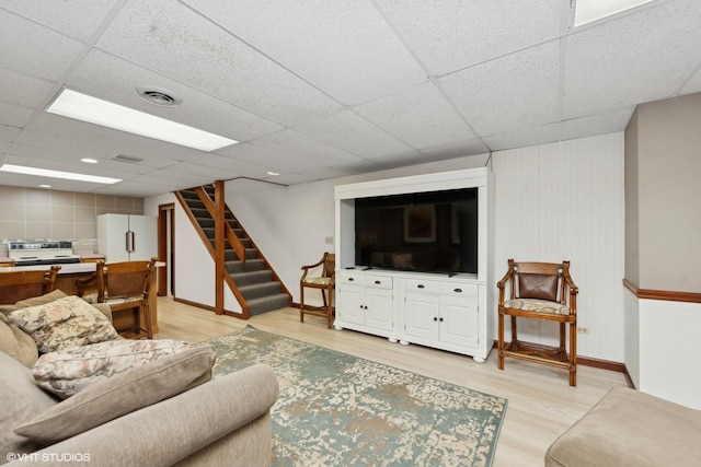 living room featuring hardwood / wood-style flooring and a drop ceiling