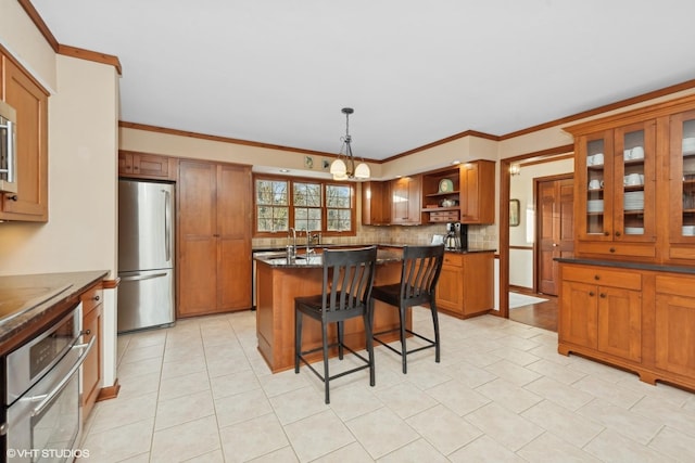 kitchen featuring a kitchen island, dark stone countertops, a kitchen bar, hanging light fixtures, and stainless steel appliances