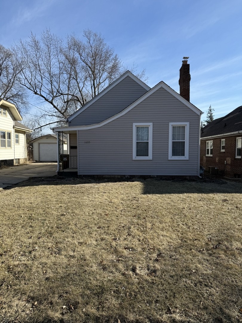 view of home's exterior featuring an outbuilding, a garage, and a yard