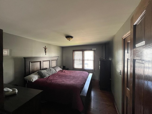 bedroom with dark hardwood / wood-style floors