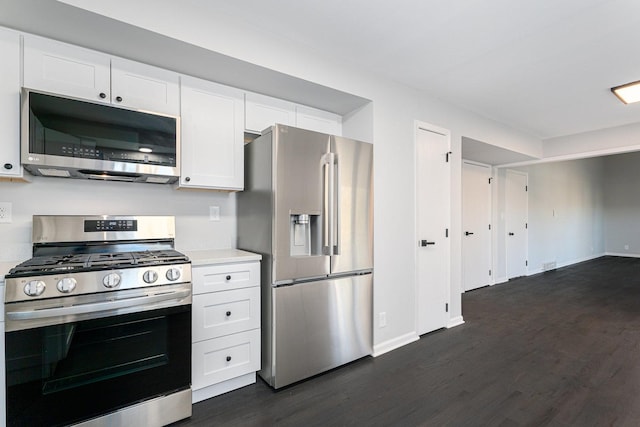 kitchen featuring appliances with stainless steel finishes, dark wood-type flooring, and white cabinets