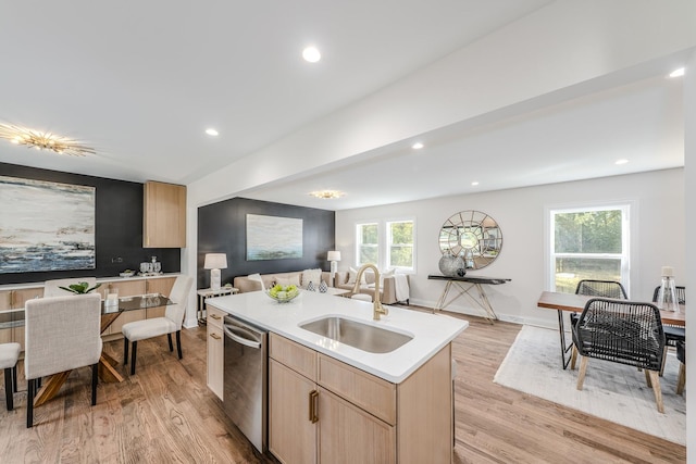 kitchen featuring sink, stainless steel dishwasher, a healthy amount of sunlight, a center island with sink, and light wood-type flooring