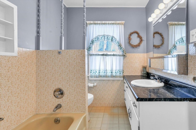 bathroom with vanity, toilet, tile walls, and a tub