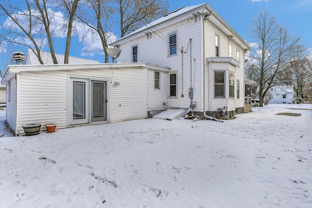 view of snow covered back of property