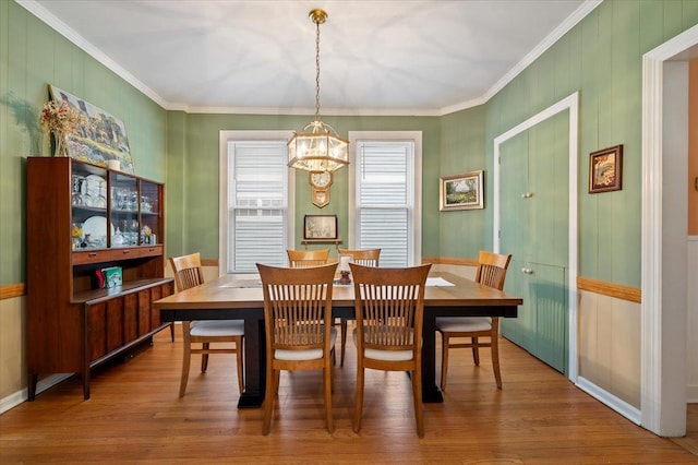 dining area with crown molding and wood finished floors