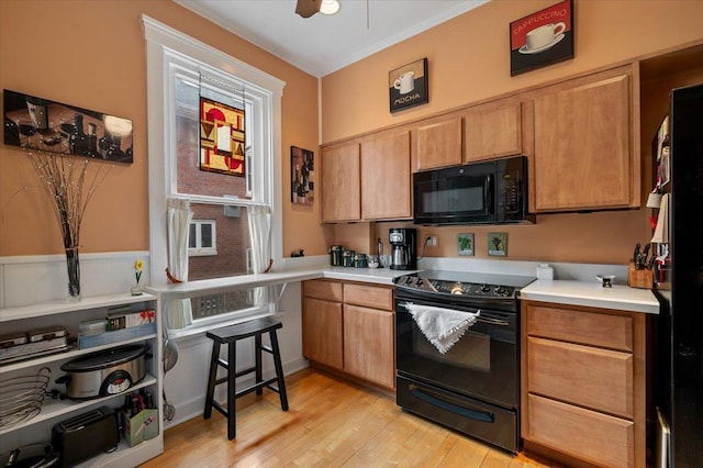 kitchen featuring light wood-type flooring, black appliances, light countertops, and a ceiling fan