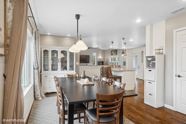 dining room with a healthy amount of sunlight and dark hardwood / wood-style flooring