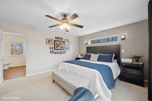 bedroom with light carpet, ensuite bath, and ceiling fan