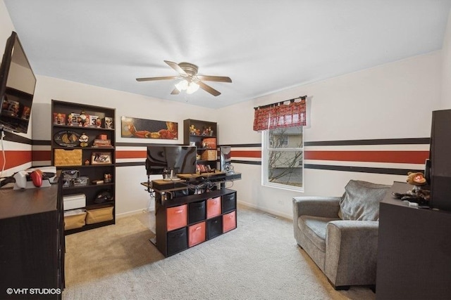 carpeted home office featuring ceiling fan