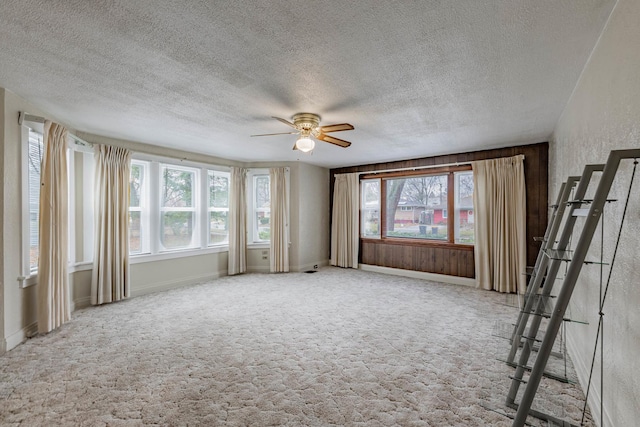 carpeted spare room featuring ceiling fan and a textured ceiling