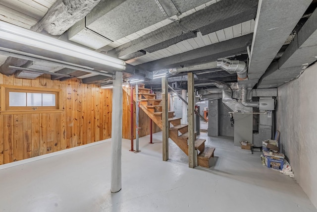 basement with heating unit and wooden walls