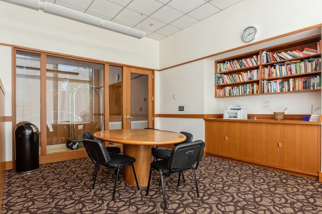 dining room featuring a drop ceiling and carpet floors