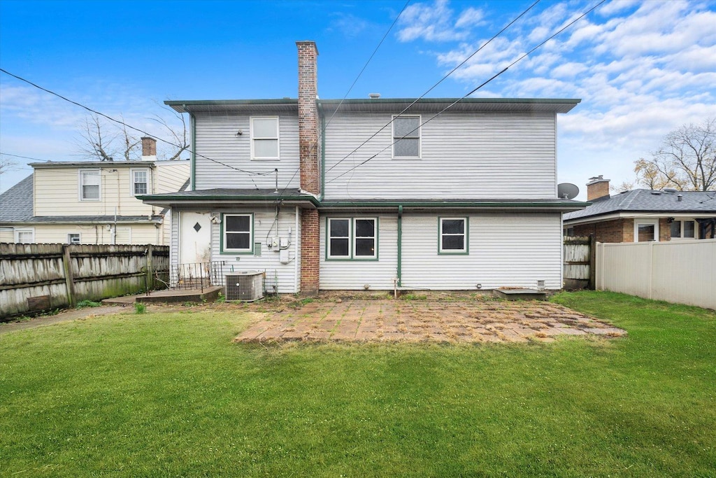 back of property featuring a yard and central AC unit