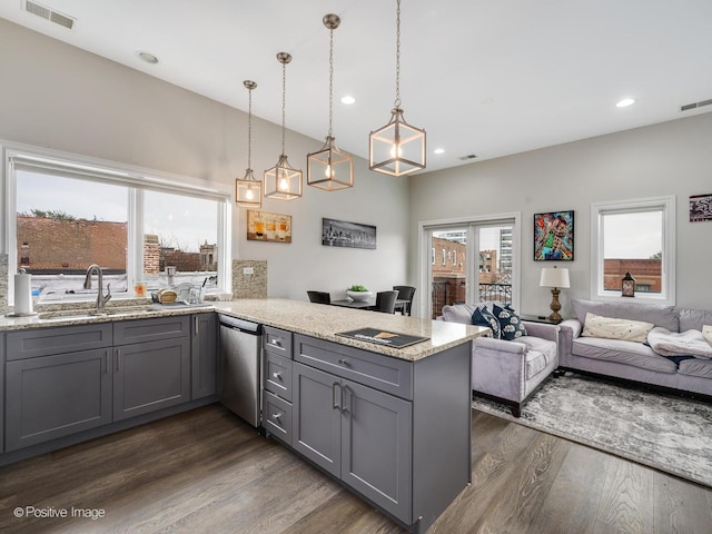 kitchen featuring gray cabinets, dishwasher, sink, hanging light fixtures, and light stone countertops