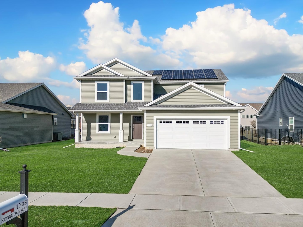 view of front of property featuring central AC unit, a front lawn, solar panels, and a porch