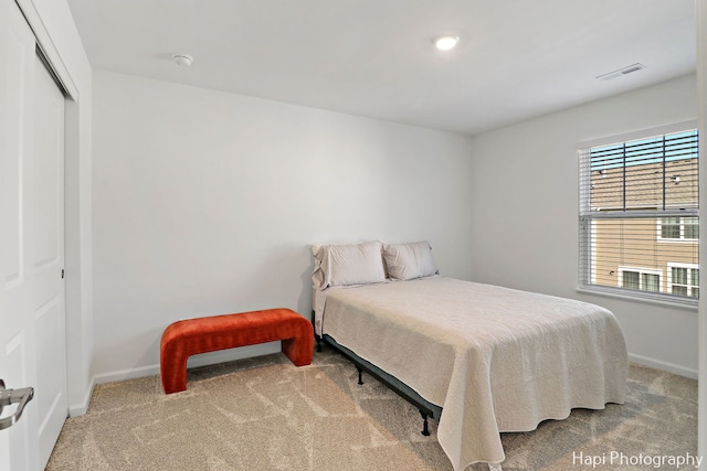 bedroom with light colored carpet and a closet