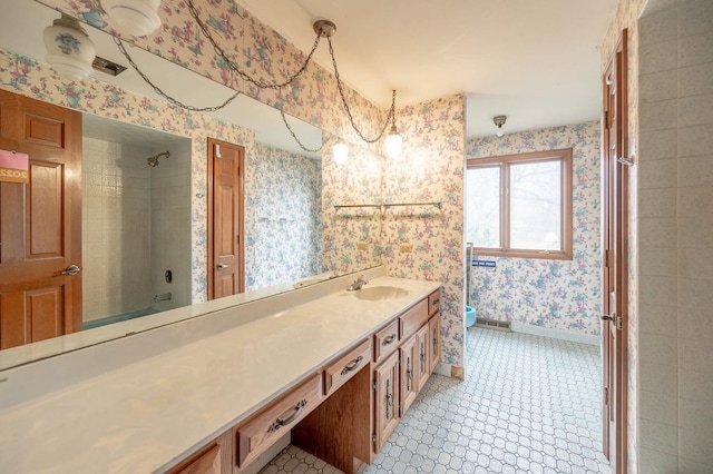 bathroom featuring vanity, a tile shower, and toilet